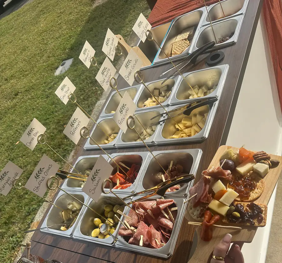 The full cart: labelled bins with gold card holders and a guest board, outdoors on a lawn