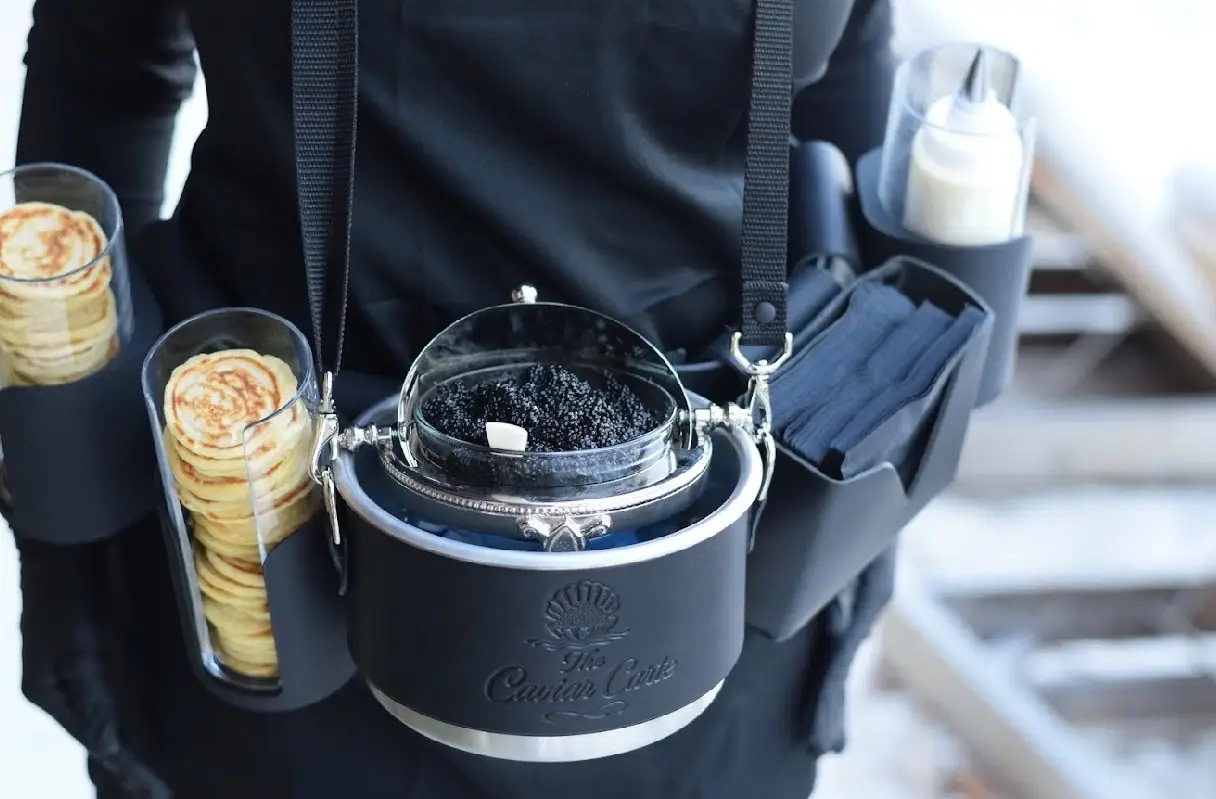 The Caviar Carte belt set with blini stacks, crème fraîche, the embossed tin and cocktail napkins