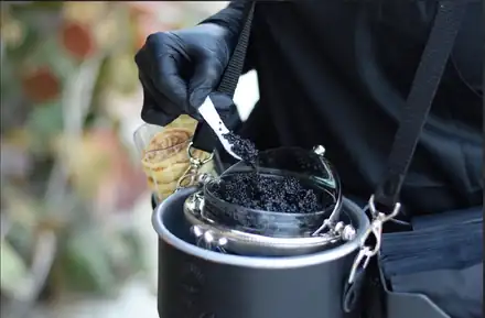 Caviar being spooned from the signature tin